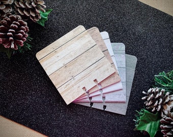 May include: A set of five decorative paper sheets with a wood grain pattern, a white and gray pattern, and a solid gray pattern. The sheets are bound together with metal rings.