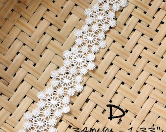 May include: White lace trim with a delicate floral pattern. The trim is 1.33 inches wide and is shown on a woven background.