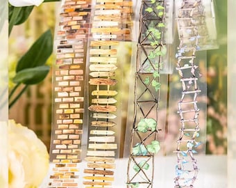 May include: Four rolls of decorative washi tape with different designs. The designs include a brick wall, a picket fence, a trellis with vines, and a ladder with flowers.