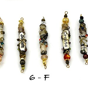 May include: Five beaded charms with different words and designs. The charms are made of white beads, brown beads, gold beads, and other colorful beads. The words on the charms are "So cute", "Create", and "Love".