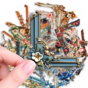 May include: A collection of decorative corner stickers featuring blue and gold frames adorned with intricate floral arrangements. The stickers display various botanical designs, including roses and small white blossoms, set against a white background.