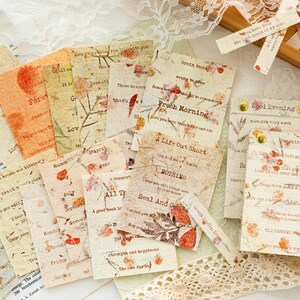 Puede incluir: Una colecci&oacute;n de ef&iacute;meras de papel de estilo vintage con flores prensadas y citas inspiradoras. El papel es beige y crema con acentos marrones y rojos. Las citas incluyen "A Life Cut Short", "Fresh Morning", "Good Evening", y "All The", entre otras.