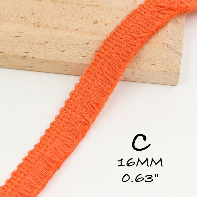 K&ouml;nnte beinhalten: Orangefarbener Baumwollbesatz mit Fransen. Der Besatz ist 1,6 cm breit.