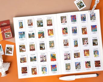 Puede incluir: Un cuaderno blanco con un patrón de cuadrícula en las páginas. El cuaderno está lleno de pequeñas pegatinas cuadradas que muestran varias pinturas de Matisse. Las pegatinas están dispuestas en filas y columnas. El cuaderno está abierto y acostado plano sobre una superficie marrón.