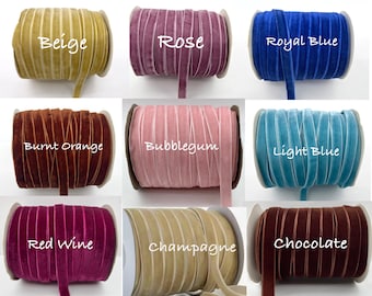 May include: A collection of spools of velvet ribbon in various colors, including beige, rose, royal blue, burnt orange, bubblegum, light blue, red wine, champagne, and chocolate. Each spool is labeled with its color name in white script.