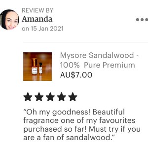 Op de afbeelding: Twee kleine flesjes Mysore Sandelhout etherische olie, 100% pure premium, op een witte achtergrond. De flesjes zijn van helder glas met gouden dopjes en etiketten. Het product kost AU$7,00. Een vijfsterrenrecensie luidt "Oh my goodness! Beautiful fragrance one of my favourites purchased so far! Must try if you are a fan of sandalwood."