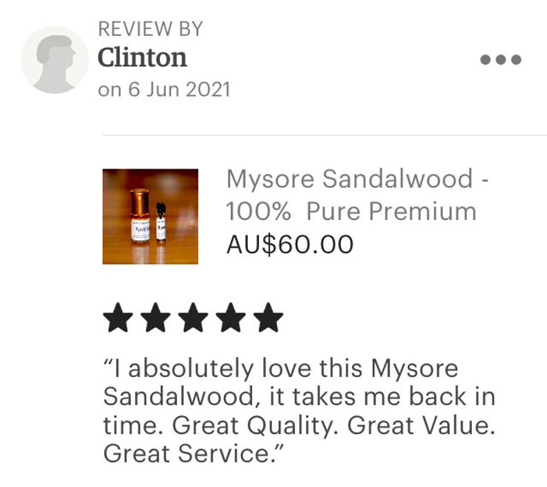 Op de afbeelding: Twee kleine flesjes Mysore-sandelhout etherische olie, een 100% puur premium product, voor AU$60,00. De flesjes zijn van amberkleurig glas met gouden dopjes en etiketten. Het product is met vijf sterren beoordeeld.