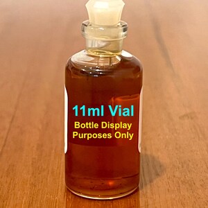 May include: A clear glass bottle with a white plastic stopper filled with a brown liquid. The bottle is labeled "11ml Vial Bottle Display Purposes Only".