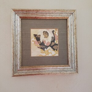 May include: A framed print of a Japanese demon with white hair and a black and gold costume. The demon is depicted in a traditional Japanese style with intricate details.