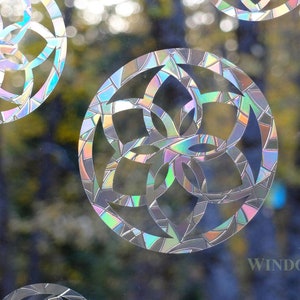 May include: A set of iridescent window clings featuring a geometric flower design. The clings are made of a clear, durable material and are easy to apply and remove.  WINDOW GEMS™