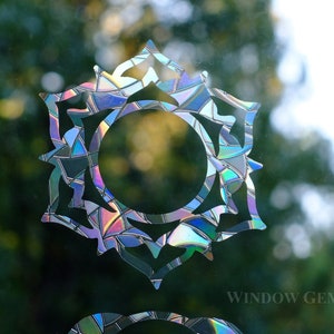 May include: Two iridescent window decals featuring the symbols for the heart and throat chakras. The decals are made of a holographic material that shimmers in the light. The text "WINDOW GEMS" is visible in the bottom right corner of the image.