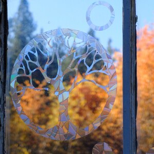 May include: A stained glass window with a tree design. The tree is made of many small pieces of glass in different colors. The window is set in a wooden frame. The text "WINDOW GEMS&trade;" is visible at the bottom of the image.