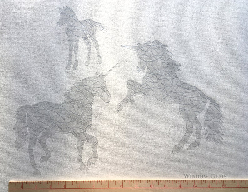 May include: Three white unicorn stencils on a white canvas background. The stencils are made of a thin, flexible material and have a delicate, intricate design. The stencils are perfect for creating unique and beautiful designs on walls, windows, and other surfaces.