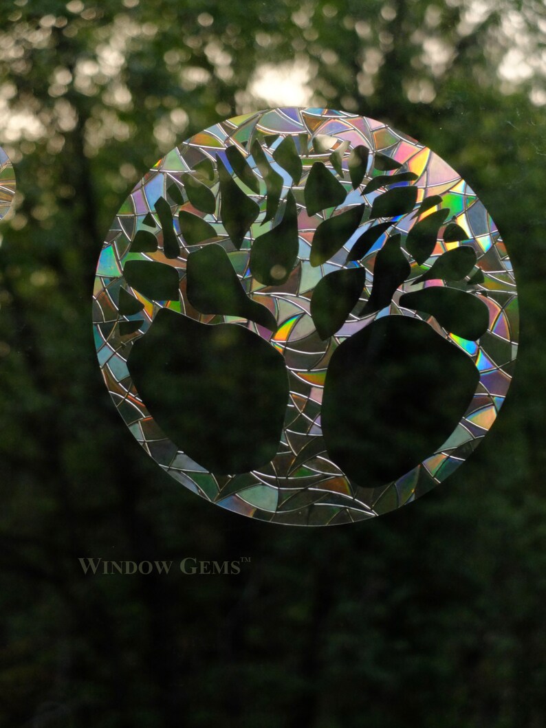May include: A colorful, iridescent window cling featuring a tree design. The cling is made of a durable, weather-resistant material and is perfect for adding a touch of nature to any window. The cling is made by Window Gems.