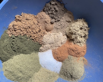 May include: A blue bowl filled with various spices and herbs, including green, brown, and white powders.