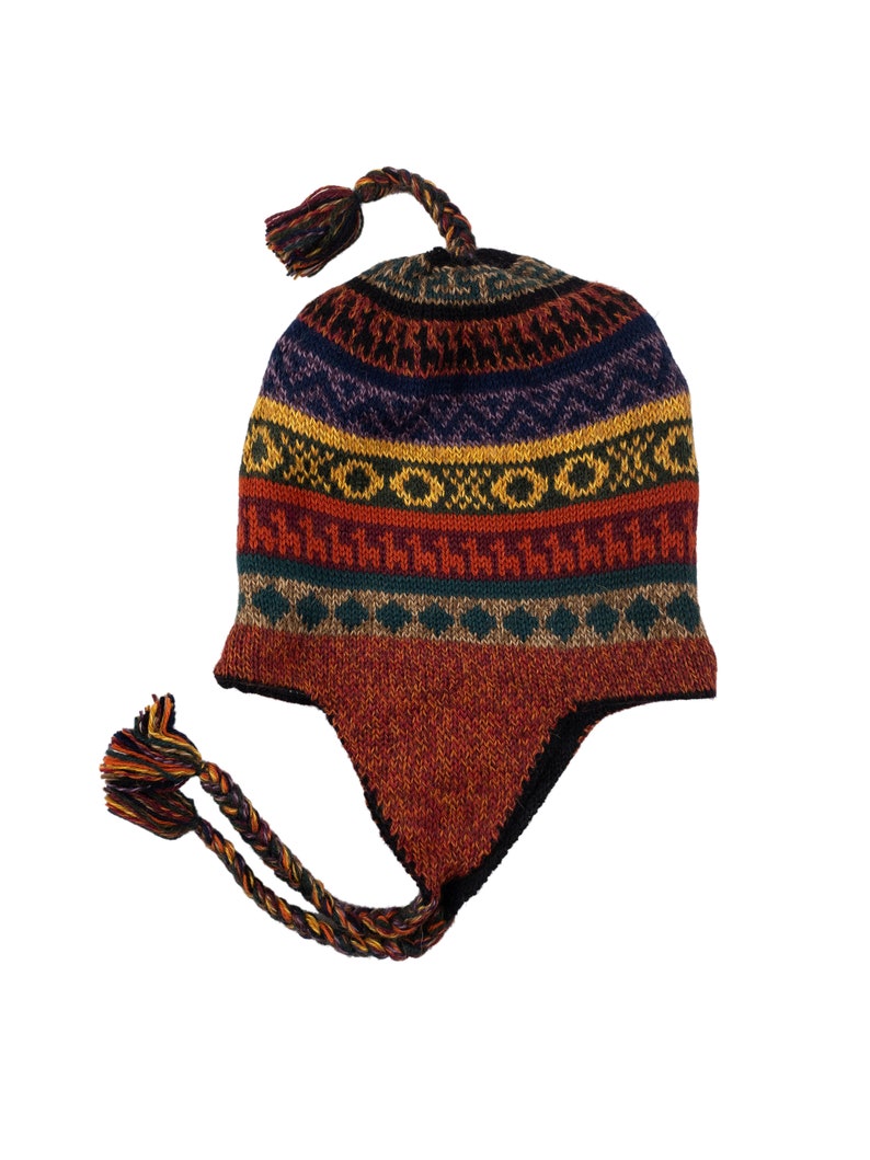 Another angle of the alpaca wool earflap hat laid flat, displaying its colorful design and tassel details.