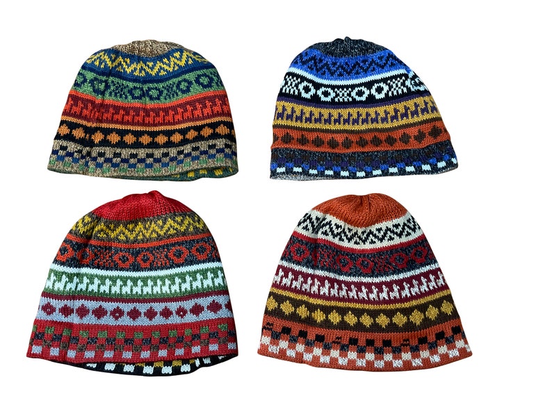 Pu&ograve; includere: Quattro berretti invernali di lana colorati con motivi geometrici. I berretti sono in tonalit&agrave; di rosso, arancione, blu e verde.