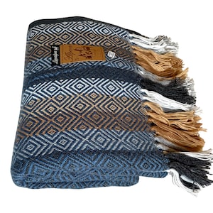 May include: A blue, brown, and white woven throw blanket with fringe. The blanket has a geometric diamond pattern and a label that reads "Alpaca."