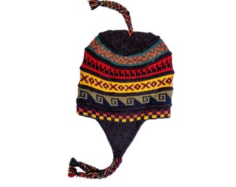 Può includere: Un cappello di lana colorato con un lungo pon pon. Il cappello presenta un motivo geometrico in tonalità di rosso, giallo, verde e blu su uno sfondo marrone scuro.