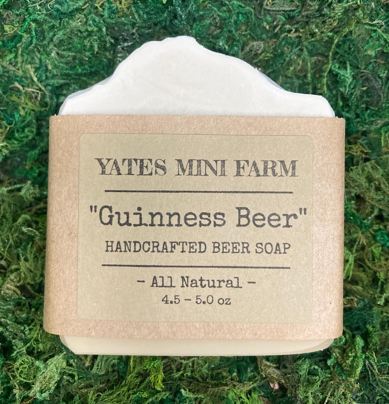 May include: A bar of handcrafted soap with a white top and a brown paper label. The label reads "YATES MINI FARM" and "Guinness Beer" with "HANDCRAFTED BEER SOAP" below. The soap weighs 4.5-5.0 oz and is labeled "All Natural".