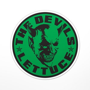 May include: A green and black circular sticker with a white border. The sticker features a black devil's head with horns and a toothy grin. The text "THE DEVILS LETTUCE" is written in a circular pattern around the devil's head.