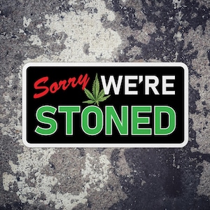 May include: A black and white sign with a green marijuana leaf and the text "Sorry We're Stoned".