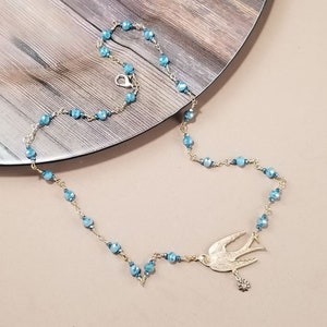 Twinkling 2 Tone Blue Beads, Brushed Brass Bird, Brass and Crystal Flower Dangle