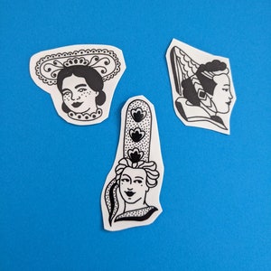 May include: Three black and white illustrations of women's faces on a blue background. Each illustration features a different hairstyle and headwear, including a lace-trimmed bonnet, a winged headdress, and a tall, ornate hat with floral details.