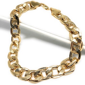 May include: A gold chain bracelet with a curb link design. The links are thick and have a textured surface.