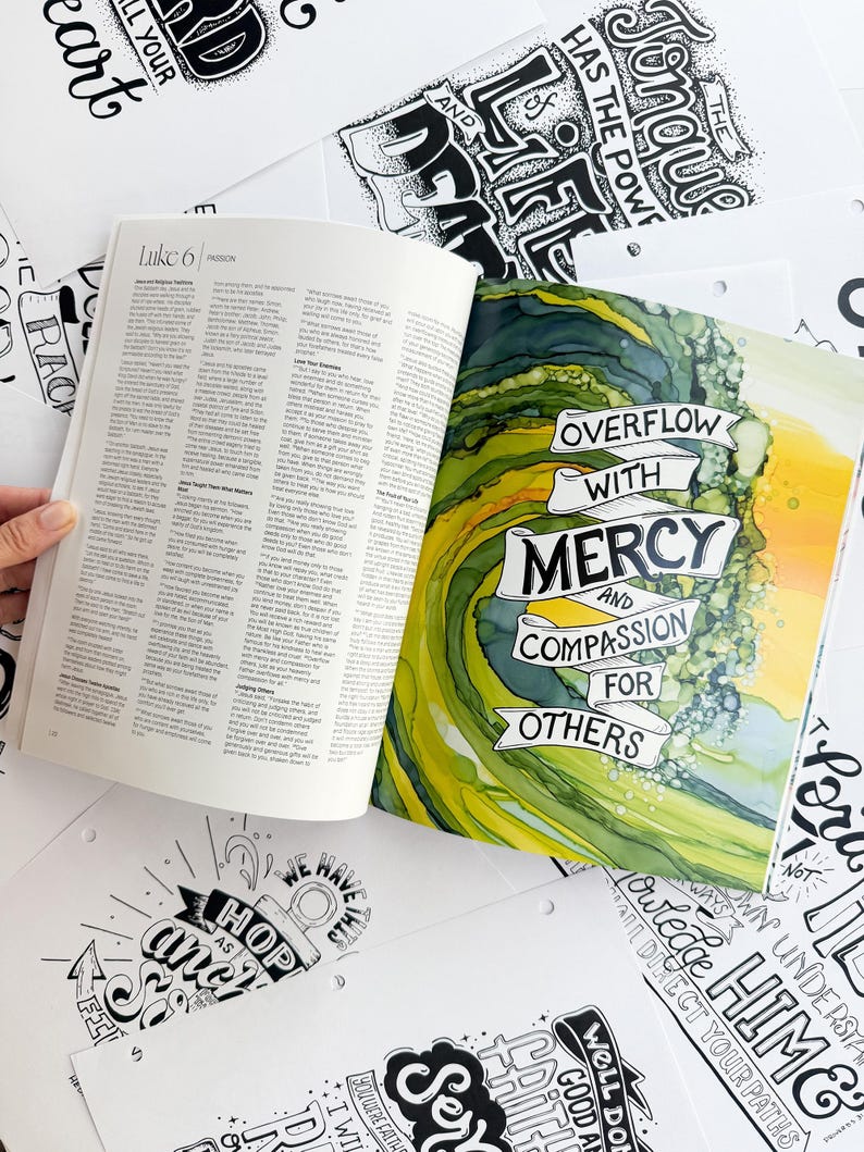 Pode incluir: Um livro aberto com texto de Lucas 6, ao lado de uma obra de arte colorida com as palavras "Overflow with Mercy and Compassion for Others". Ao redor do livro, h&aacute; v&aacute;rias impress&otilde;es de arte em preto e branco com cita&ccedil;&otilde;es inspiradoras.