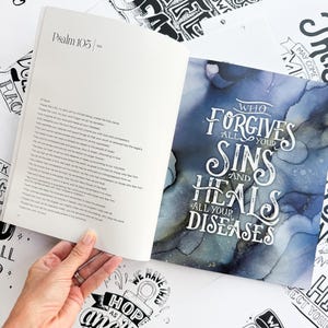 Pode incluir: Um livro aberto exibindo o Salmo 105, com uma m&atilde;o segurando as p&aacute;ginas. Ao redor do livro est&atilde;o v&aacute;rias impress&otilde;es de arte em preto e branco com cita&ccedil;&otilde;es inspiradoras e caligrafia. Uma impress&atilde;o diz: &ldquo;Quem perdoa todos os seus pecados e cura todas as suas doen&ccedil;as&rdquo;.