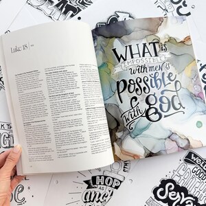 Pode incluir: Um livro aberto com texto de Lucas 18, ao lado de um di&aacute;rio com a cita&ccedil;&atilde;o "O que &eacute; imposs&iacute;vel para os homens &eacute; poss&iacute;vel para Deus". Ao redor do livro e do di&aacute;rio, h&aacute; v&aacute;rias impress&otilde;es de arte em preto e branco com cita&ccedil;&otilde;es inspiradoras.