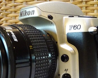 F60 silver SLR camera body with lens