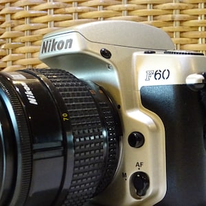 F60 silver SLR camera body with lens