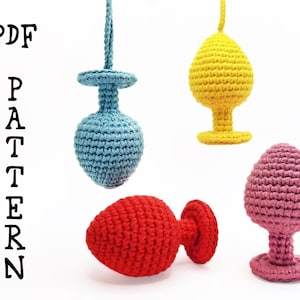 Puede incluir: Cuatro tapones de botella de ganchillo en diferentes colores: azul claro, amarillo, rojo y rosa. Los tapones tienen la forma de un tapón de botella tradicional con una parte superior redonda y una base plana.