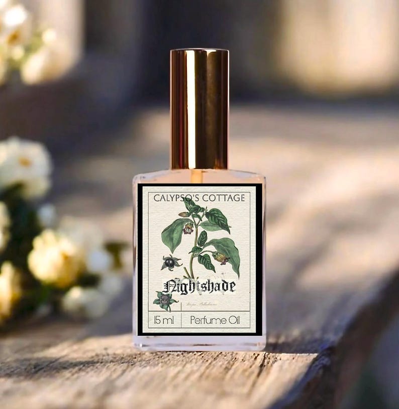 Op de afbeelding: Een parfumolie fles met een gouden dop en een etiket met botanische illustraties en het woord "Nightshade". Het etiket bevat ook de tekst "Calypso's Cottage" en "15 ml Perfume Oil".