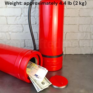 Könnte beinhalten: Ein leuchtend roter, zylindrischer Feuerlöscher-Tresor mit schwarzem Schlauch. Er ist 51 cm hoch, 15 cm breit, hat einen Gewindebodendeckel mit 90 mm Durchmesser und wiegt ca. 2 kg, abgebildet mit Papiergeld im Inneren.