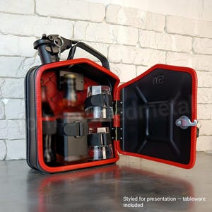 Pu&ograve; includere: Bar portatile nero e rosso a forma di tanica. L'interno rosso trapuntato presenta cinghie per contenere bottiglie e bicchieri. La porta &egrave; aperta. L'esterno ha una maniglia e un meccanismo di chiusura.