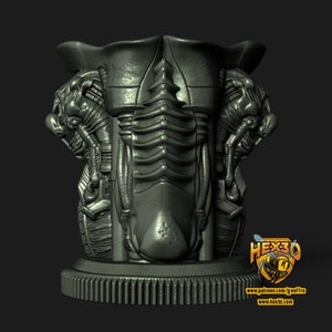 May include: A gray, 3D-printed, futuristic-style vase with intricate details. The vase features a gear-like base and a detailed, textured body with robotic and organic elements. The design includes two side figures and a central, ribbed structure.