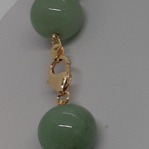 May include: A green jade bead necklace with a gold clasp.