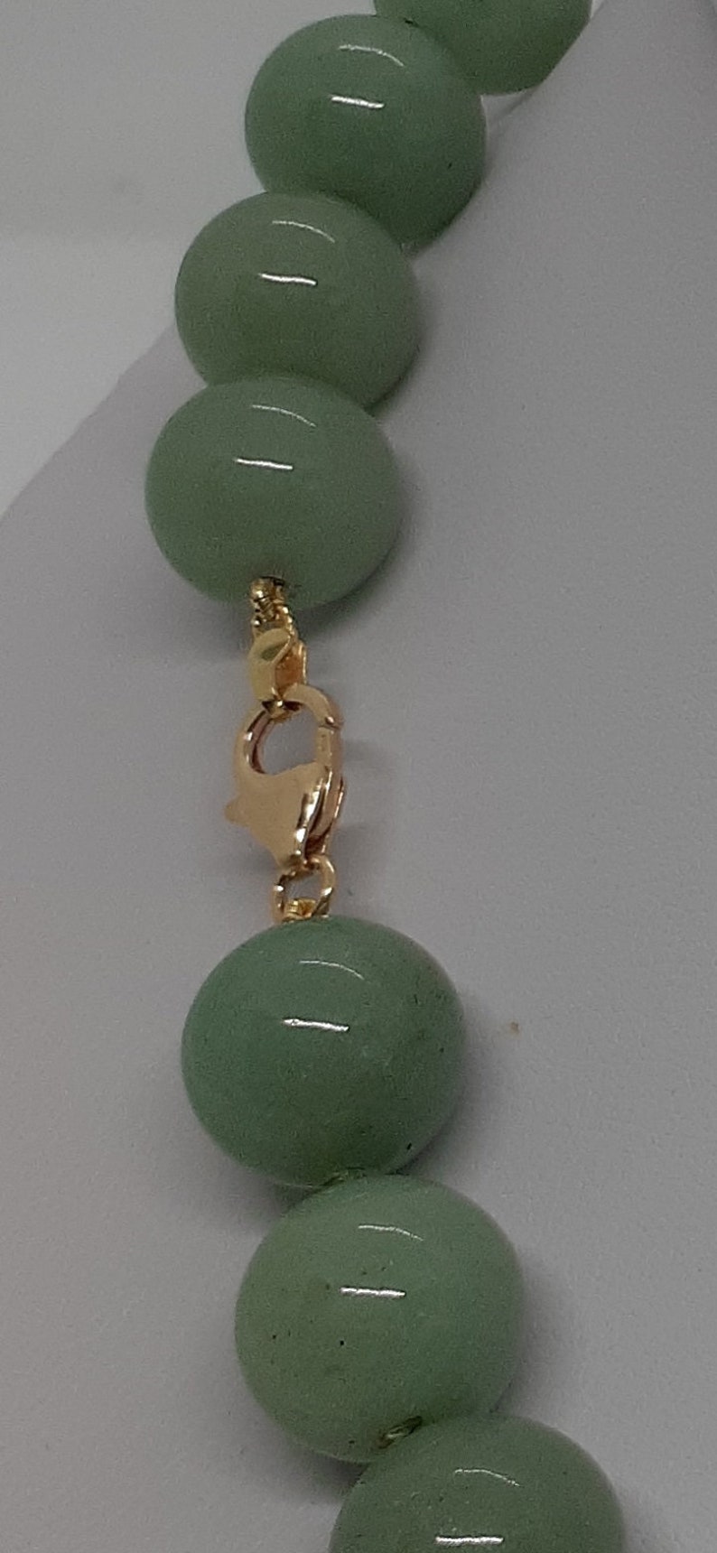 May include: A green jade bead necklace with a gold clasp.