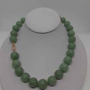 May include: A green jade bead necklace with a gold clasp.