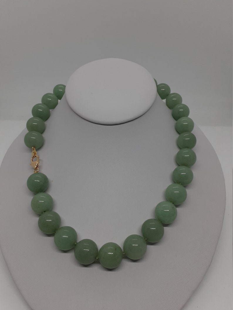 May include: A green jade bead necklace with a gold clasp.