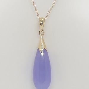May include: A gold chain necklace with a teardrop-shaped pendant. The pendant is made of lavender-colored stone.