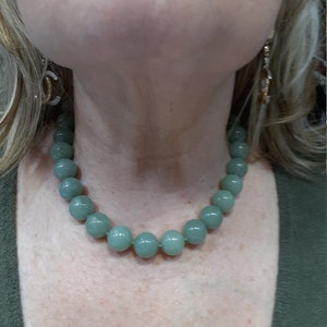 May include: A light green beaded necklace with round beads.