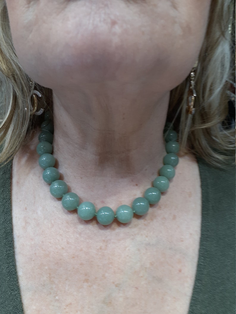 May include: A light green beaded necklace with round beads.