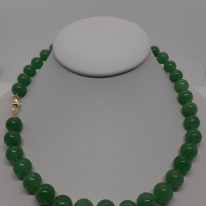 May include: A green jade bead necklace with a gold clasp.