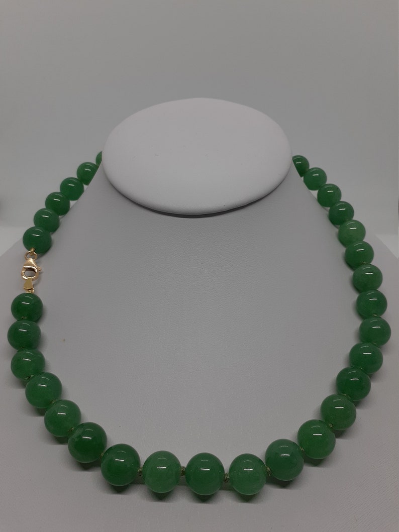 May include: A green jade bead necklace with a gold clasp.