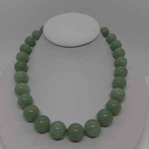May include: A green jade bead necklace with round beads.