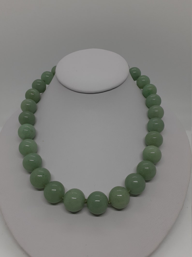 May include: A green jade bead necklace with round beads.